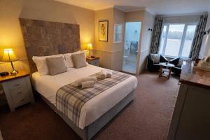 a bedroom with a large bed with two towels on it at Springburn Farmhouse in Spean Bridge