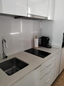 a white kitchen with a sink and a microwave at Rooftop Teatro Aveiro in Aveiro +9 photos