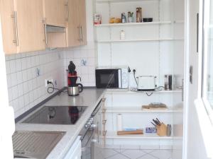a white kitchen with a sink and a microwave at Villa Hochwald Familienhaus in Geisfeld