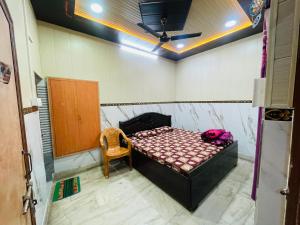 a small room with a bed and a chair at Dwarkapuri Paras guest house in Mathura