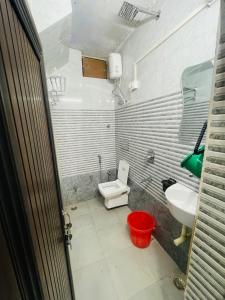 a small bathroom with a toilet and a sink at Dwarkapuri Paras guest house in Mathura