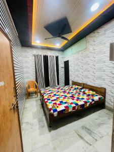 a bedroom with a bed with a colorful comforter at Dwarkapuri Paras guest house in Mathura