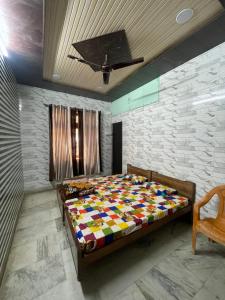 a bedroom with a bed with a colorful quilt at Dwarkapuri Paras guest house in Mathura