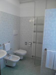 a bathroom with a toilet and a sink and a shower at Hotel Alla Dolina in Sistiana
