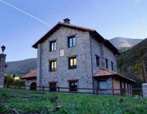 una gran casa de piedra en la cima de una colina en Hotel Eigón, en Posada de Valdeón