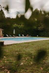 a swimming pool with lounge chairs in a yard at Logis - Hotel Restaurant du Parc in Cransac