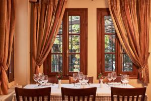 una mesa con copas de vino en una habitación con ventanas en Hotel Dryades and Spa en Agios Lavredios
