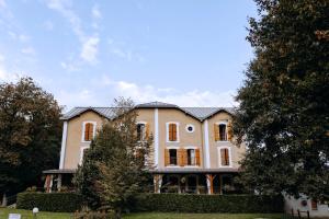 a large white house with trees in front of it at Logis - Hotel Restaurant du Parc in Cransac