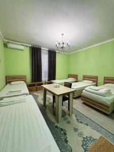 a room with four beds and a table in it at Diamond Hotel Даймонд Отель in Var-Kyshtak