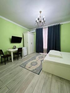 a bedroom with a bed and a desk and a television at Diamond Hotel Даймонд Отель in Var-Kyshtak
