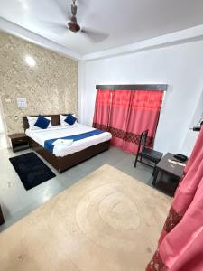 a bedroom with a bed and a red curtain at Hotel Arawali Hill in Udaipur