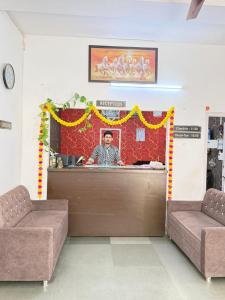 a man standing behind a counter in a room at Hotel Arawali Hill in Udaipur