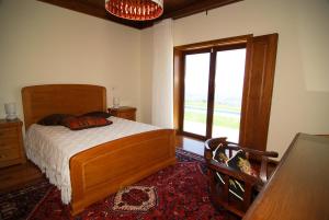 a bedroom with a bed and a large window at Quinta do Alto in Celorico de Basto