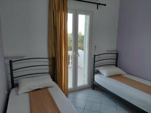 two beds sitting in a room with a window at NATALIA in Lixouri