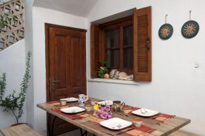 a wooden table with plates and food on it at Sappho House in Skala Eresou