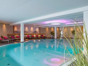 a pool in a hotel with chairs and tables at Hotel Adapura Wagrain in Wagrain