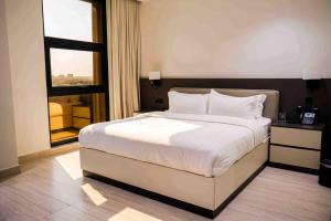 a bedroom with a large white bed and a window at فندق جديل2 - Jadeel Hotel 2 in Al Khobar