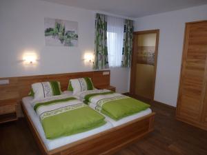 シュラートミンクにあるFerienhaus u. Appartement Knaussのベッドルーム1室(大型ベッド1台、緑の枕付)