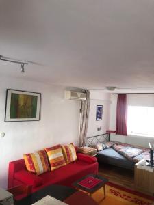 a living room with a red couch and a bed at Appartement Studio 1 Punat Insel Krk in Punat