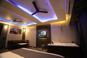 a bedroom with a bed and a tub and a ceiling at Hotel Namaste With Jacuzzi I Best For Couples and Corporate I Noida in Noida
