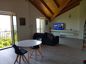 a living room with a table and chairs and a tv at Stella Maggiore in Verbania