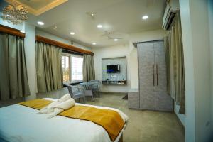 a bedroom with a large bed and a bathroom at Jai Ganesha Resort in Chālsa Mahābāri +56 photos
