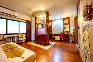 a living room with a bed and a tv in it at The Ligor City Hotel in Nakhon Si Thammarat