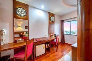 a dining room with a wooden table and chairs at The Ligor City Hotel in Nakhon Si Thammarat