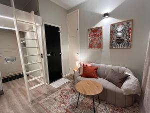 a living room with a couch and a table at Central Kamppi Micro Loft, Quiet Courtyard in Helsinki