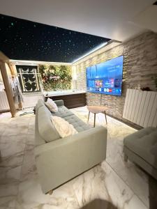 a living room with a couch and a tv at Maison avec spa in Maisdon-sur-Sèvre