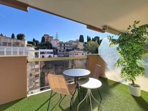 a table and chairs on a balcony with a view at Hello Menton in Menton