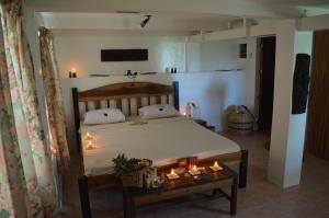 a bedroom with a bed and a table with candles at The Amazing Villa in Anepahan