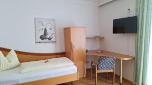 a small room with a desk and a bed and a table at Schwanbergerstüberl in Schwanberg