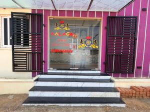 a pink building with steps in front of a store at AalaGo in Thiruchendur