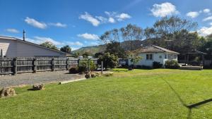 a yard with a house and a fence at Bach 30 at Waimārama Beach in Waimarama