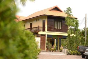 a large wooden house with a roof at River Jam Amphawa in Amphawa