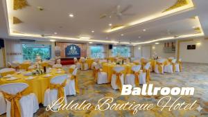 a banquet hall with yellow tables and white chairs at Lulala Boutique Hotel in Gerik