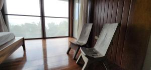 two chairs in a room with a bed and a window at The Amazing Villa in Anepahan