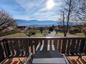 a bench on a balcony with a view of a mountain at Chambres indépendantes chez l'habitant in Saint-Pierre-dʼAlbigny