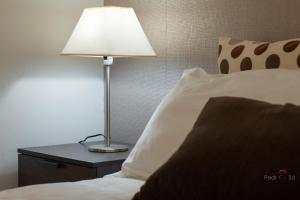 a lamp sitting on a table next to a bed at Marnoto´s City Apartment in Aveiro