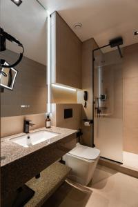 a bathroom with a toilet and a sink and a mirror at Marhaba Hotel & Spa in Tashkent