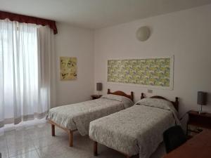 ein Schlafzimmer mit zwei Betten und einem Fenster in der Unterkunft Hotel 4 Mori in Cagliari