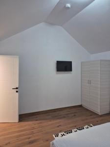 a white room with a tv on a wall at La Miruna in Comăneşti
