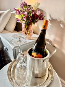 a bottle of wine in a bucket on a table with a glass at Whitaker Lodge in Swinford