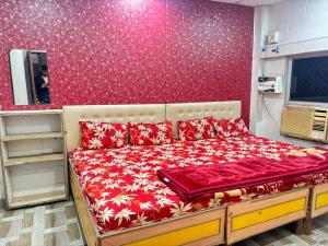 a bed in a room with a red wall at Naimisharanya Ganpati dham in Naimishāranya +15 photos