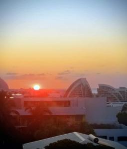 a sunset over a city with buildings and the sun at Cozy & Zen in Saint-Denis
