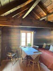 a dining room with a table and chairs and a bed at Urastova in Vassenden