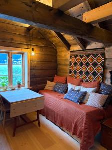 a room with two beds and a table in a cabin at Urastova in Vassenden