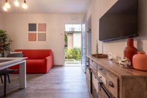 a living room with a red couch and a table at Casa con parcheggio interno gratis e tram Venezia in Favaro Veneto