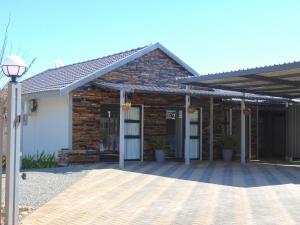 a brick building with a front entrance with a porch at Wild Olive Luxury Accommodation in Newcastle
